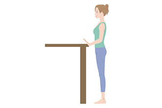 机にもたれた姿勢